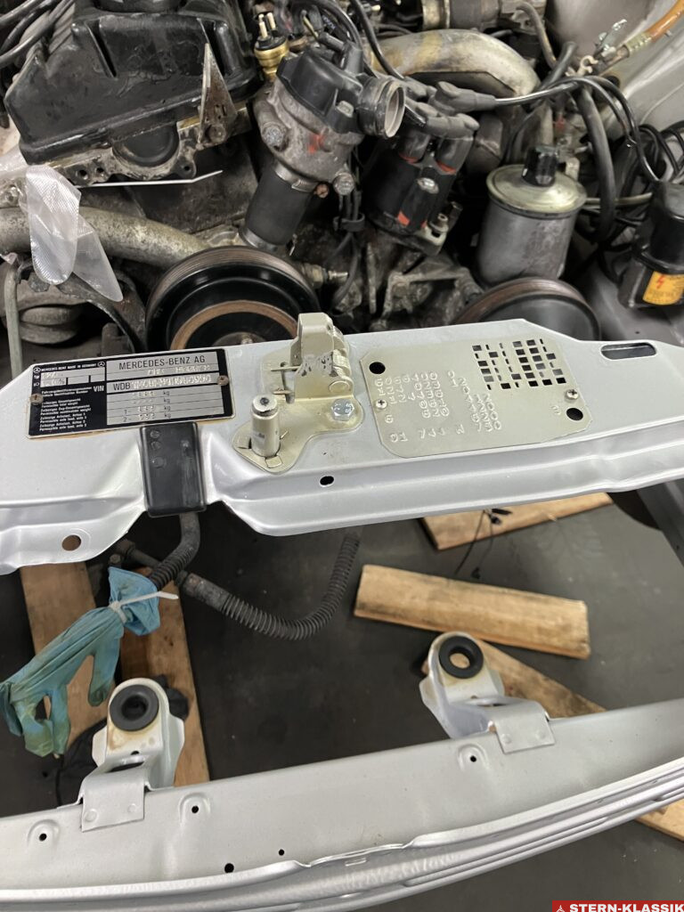 Motorhaubenriegel und Typenschild eines Mercedes-Benz W124 nach der Montage.