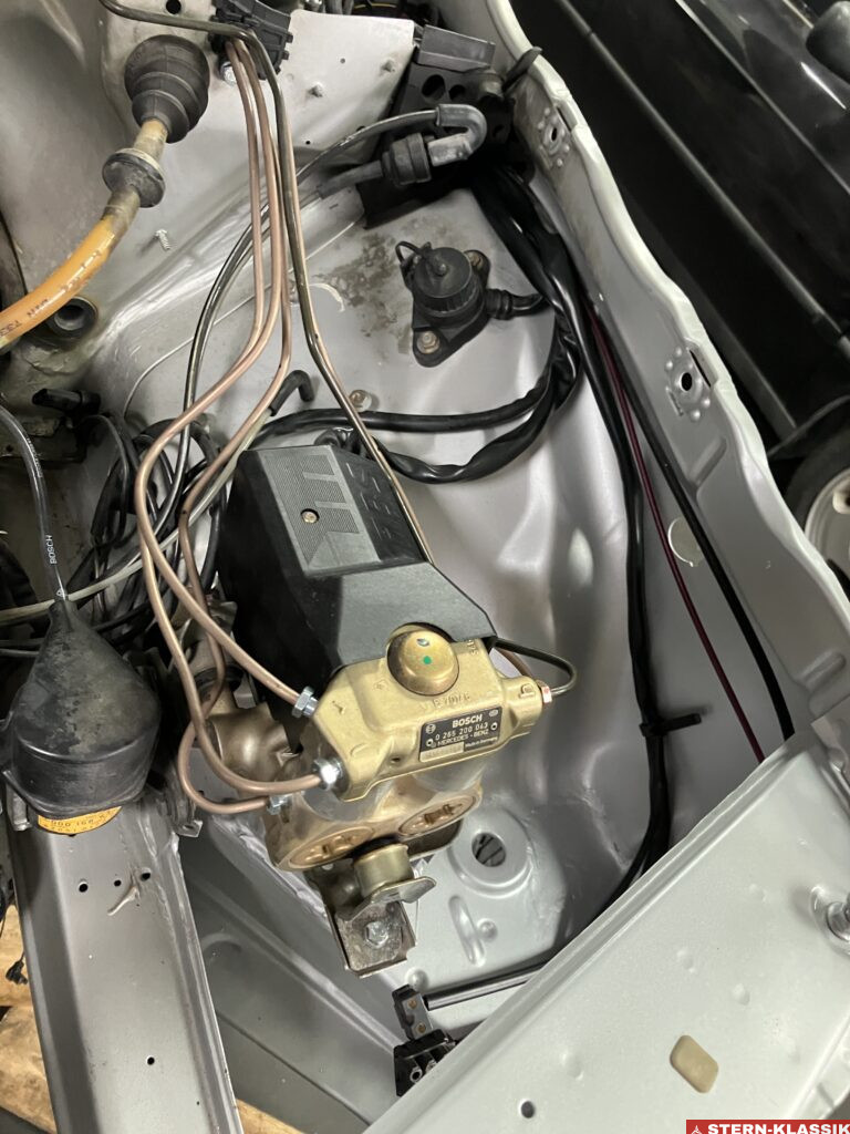 Eingebaute ABS-Pumpe mit neuen Bremsleitungen in einem Mercedes-Benz W124.